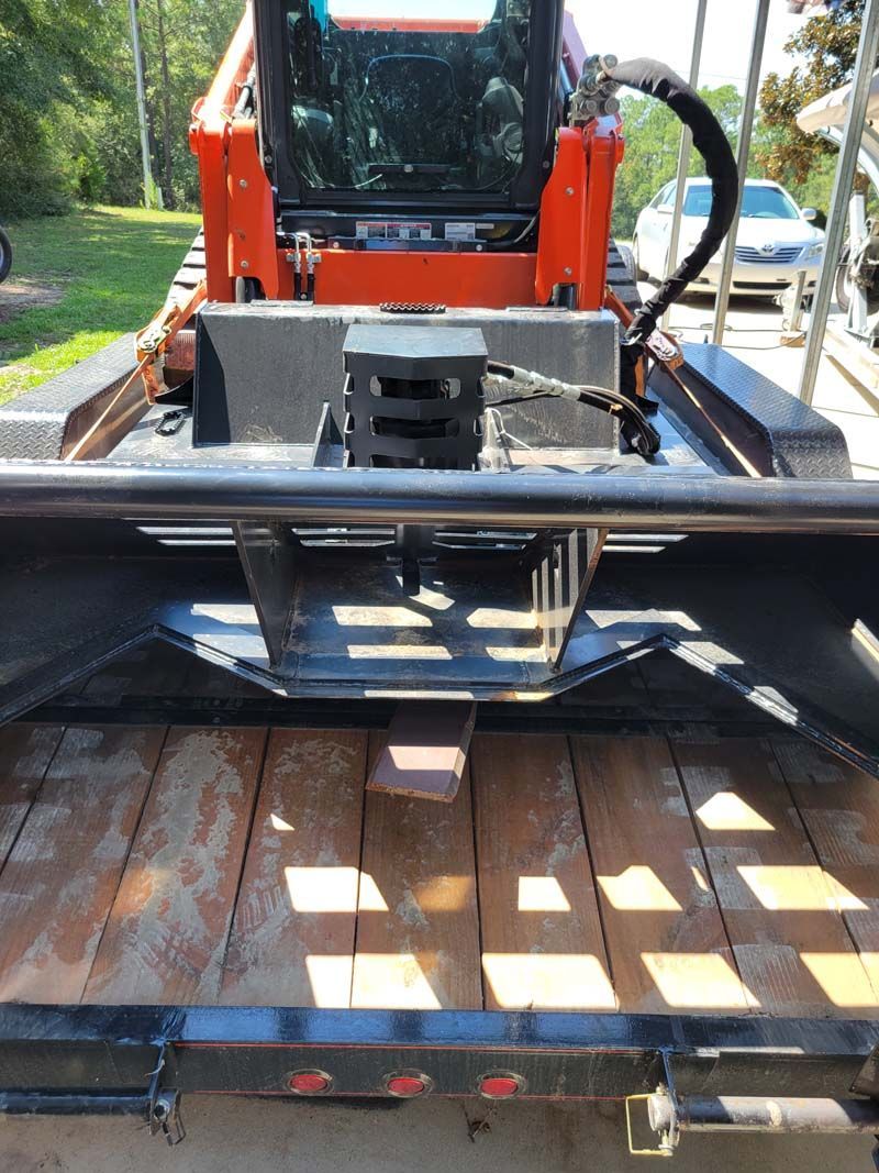 A bulldozer is sitting on top of a wooden trailer.