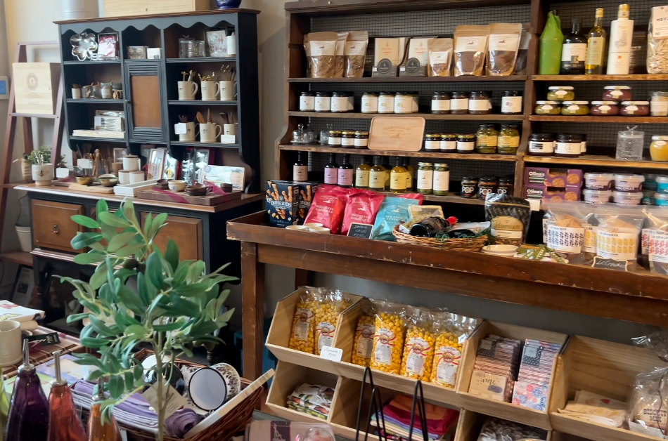 Still image from the EDWINS video at approximately 2:06:18 Interior of Pour Wine + Gifts in Cleveland Heights with wine and nonalcoholic bottles on display.