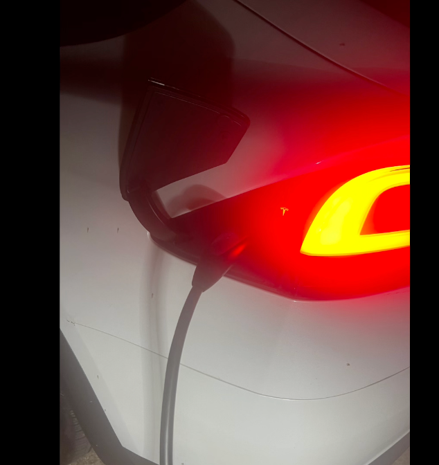 Taiji, a white Tesla Model X, connected to a Level 2 charger at the Mitsubishi dealership in Bedford, Ohio.