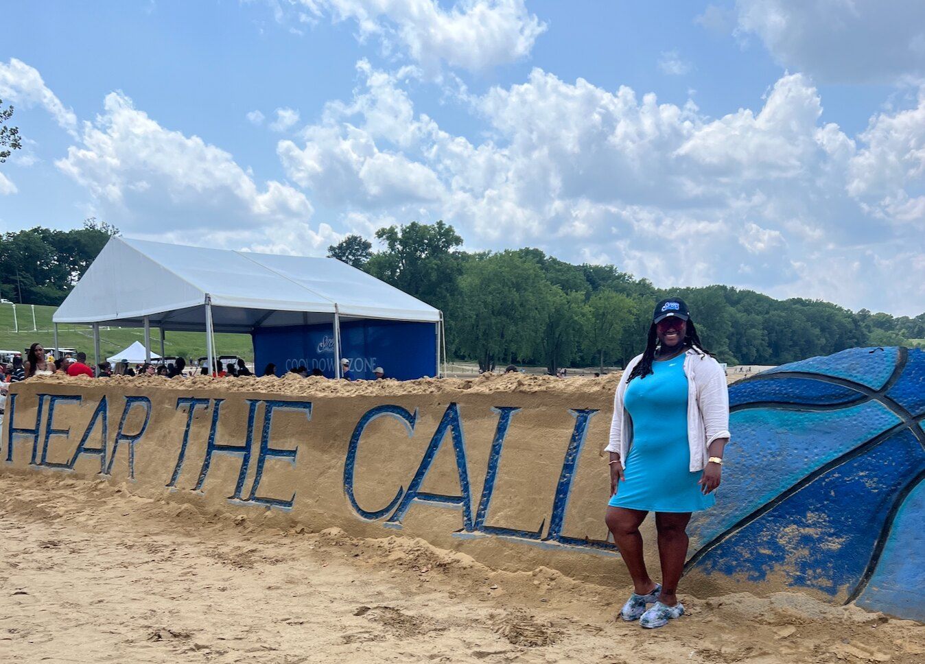 Renay Cheyenne beside the Hear the Call sand display at Cleveland Sirens FanFest at Edgewater Beach.