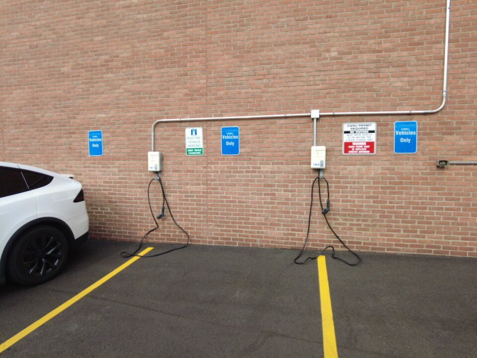 Two EverCharge EV chargers beside CWRU permit-required and CWRU vehicles-only signs in Case Western Reserve University Lot 1A.
