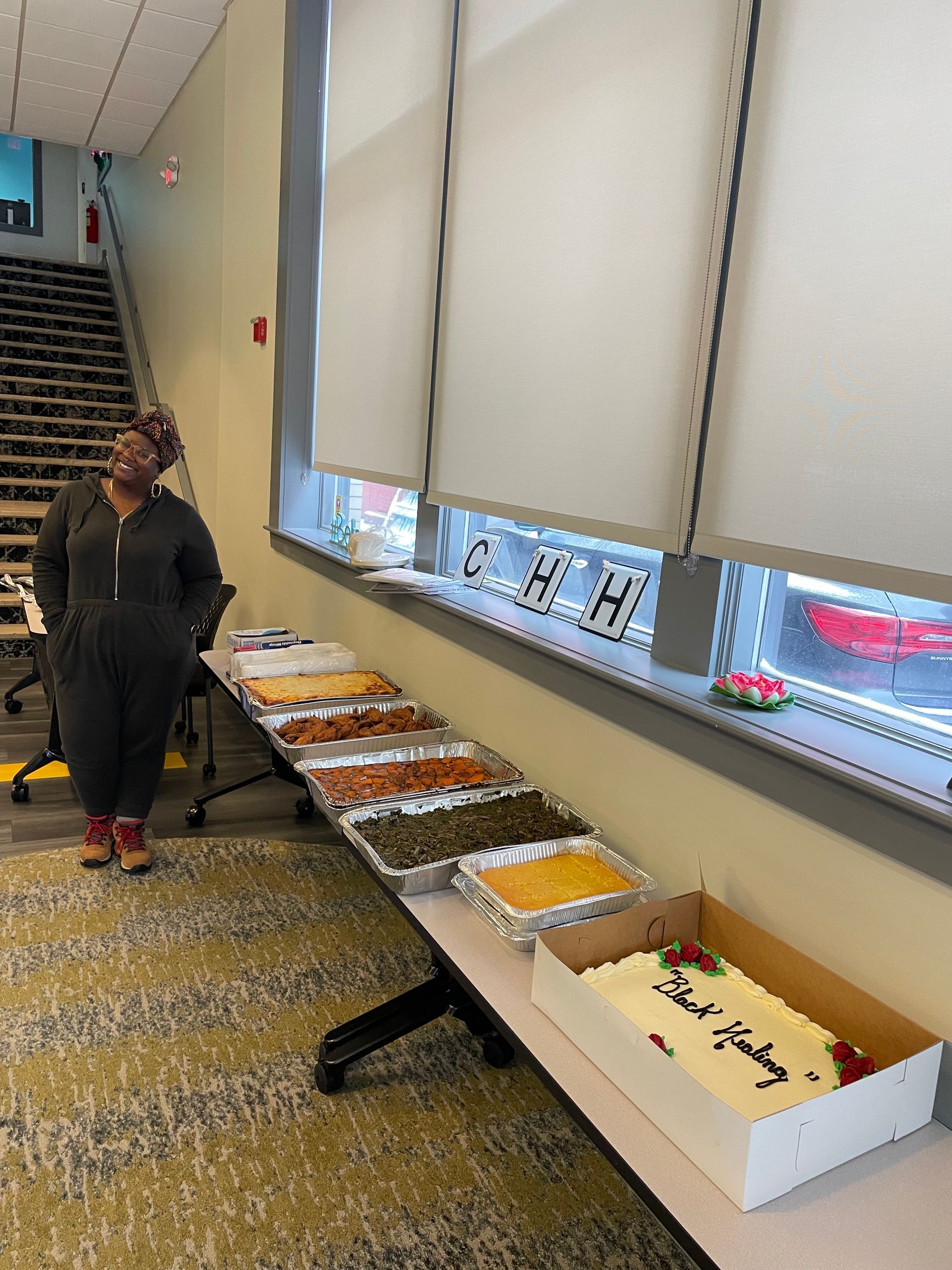 A woman is standing in front of a table full of food.