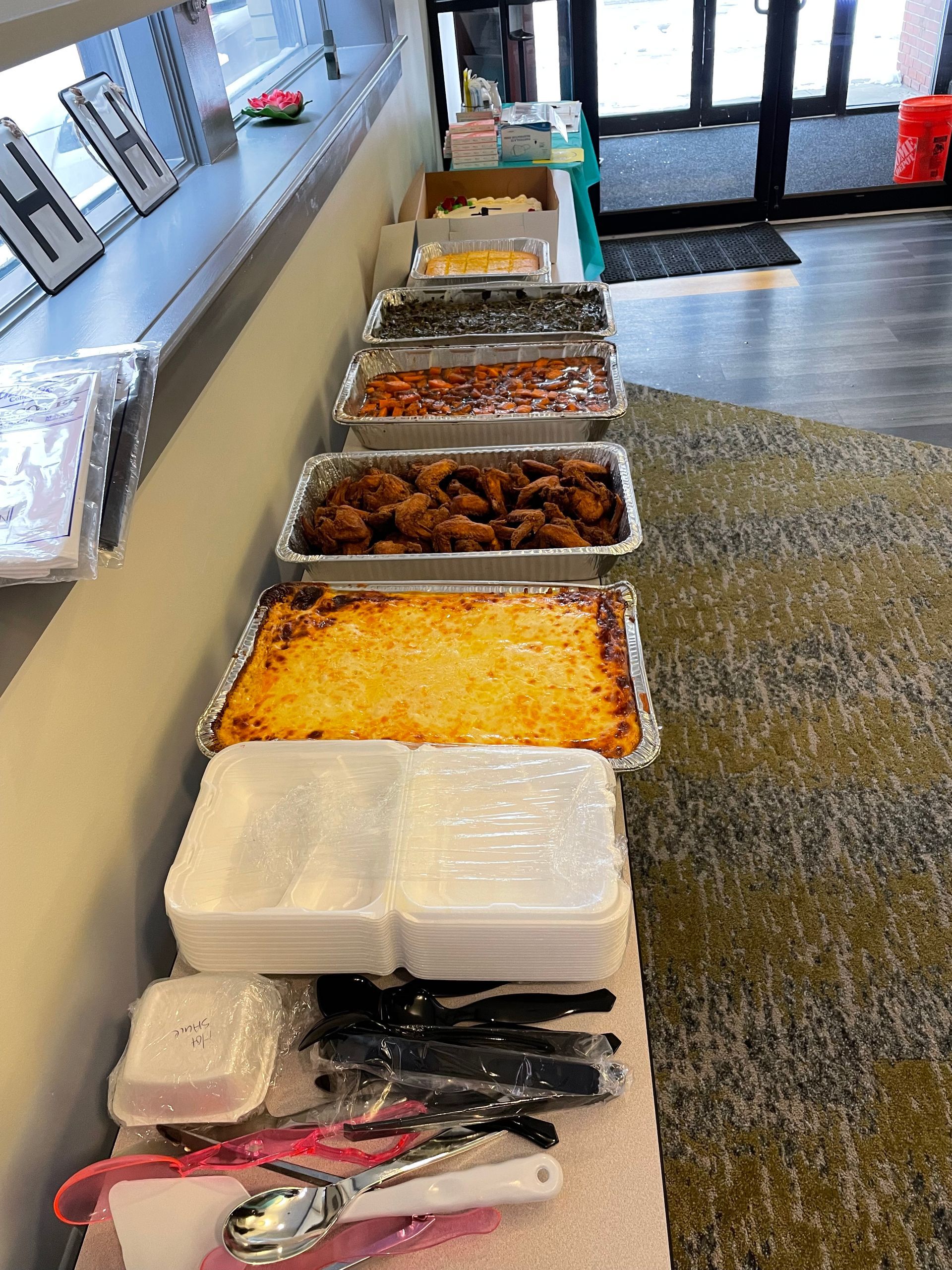 A buffet table filled with lots of food and utensils.