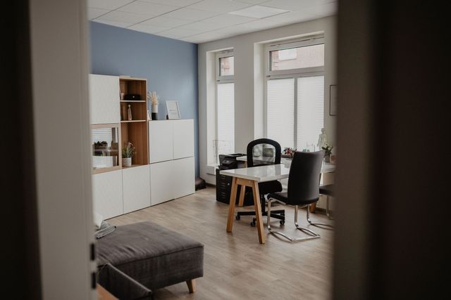 Ein Wohnzimmer mit einem Tisch und Stühlen.