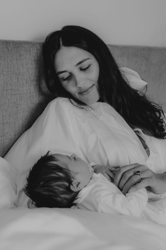 Auf einem Schwarzweißfoto stillt eine Frau ihr Baby.