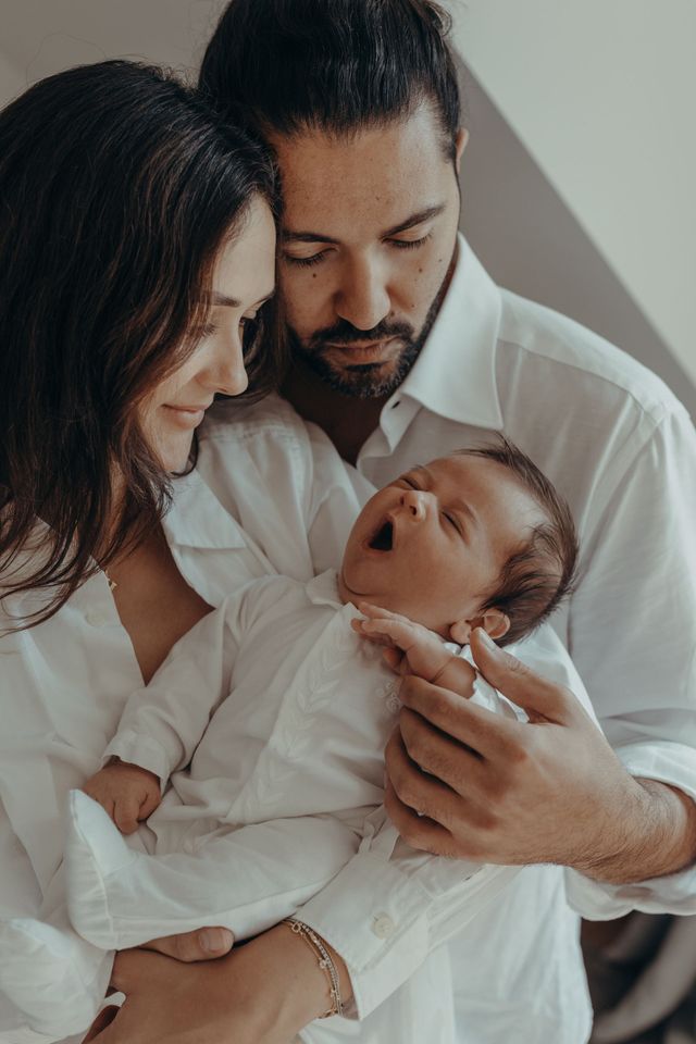 Auf einem Schwarzweißfoto stillt eine Frau ihr Baby.