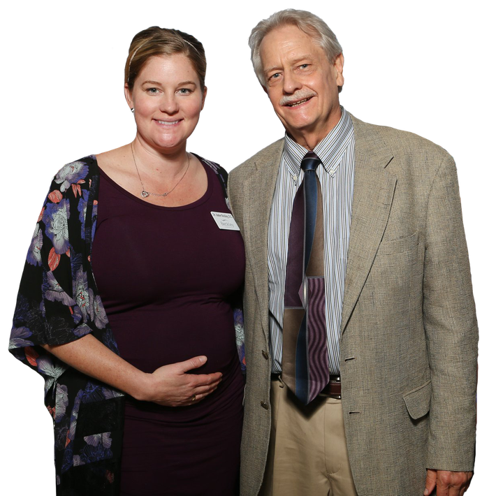 A man and a pregnant woman are posing for a picture