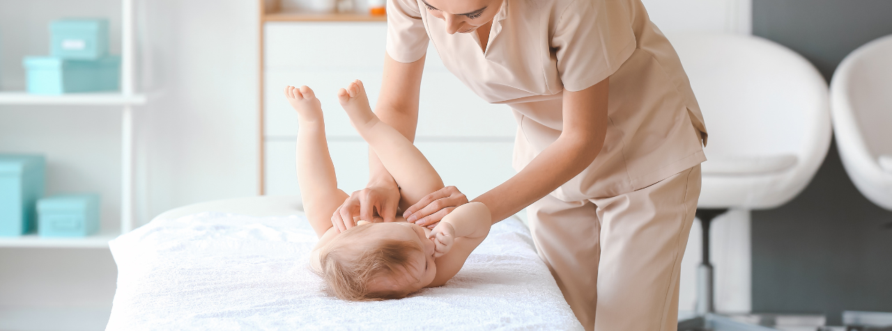 A woman is giving a baby a massage on a table.