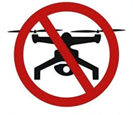 Red prohibition sign over a black drone, indicating no drones allowed.