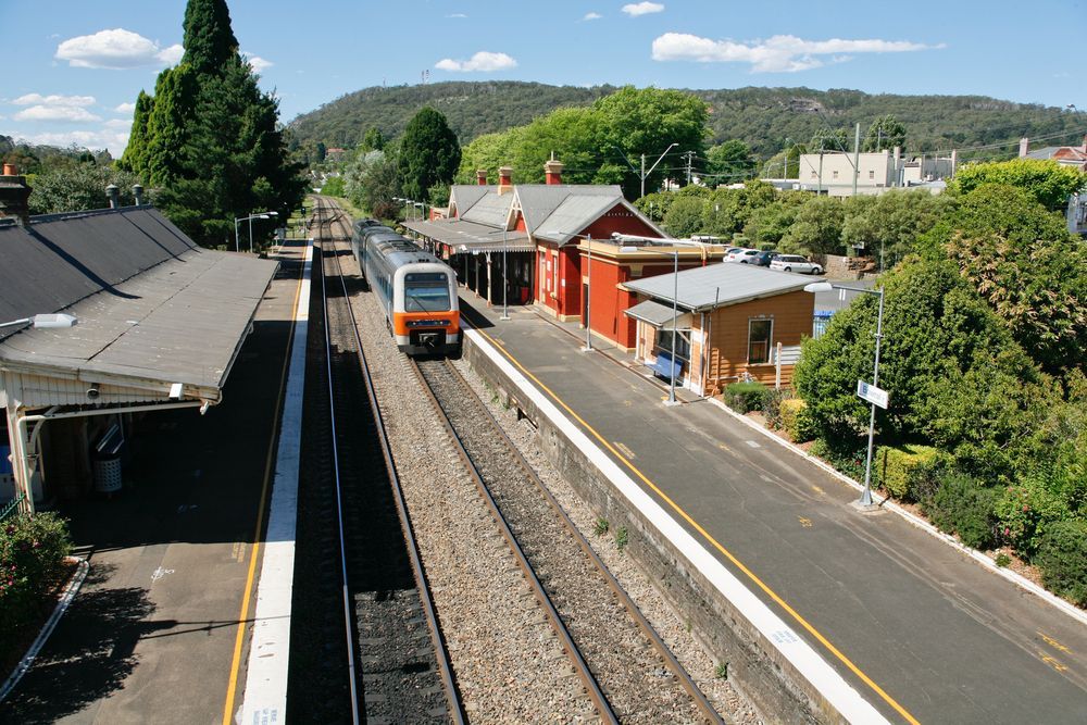 A Train is Pulling Into a Station With a Red Building — All Things Windows & Doors in Goulburn, NSW