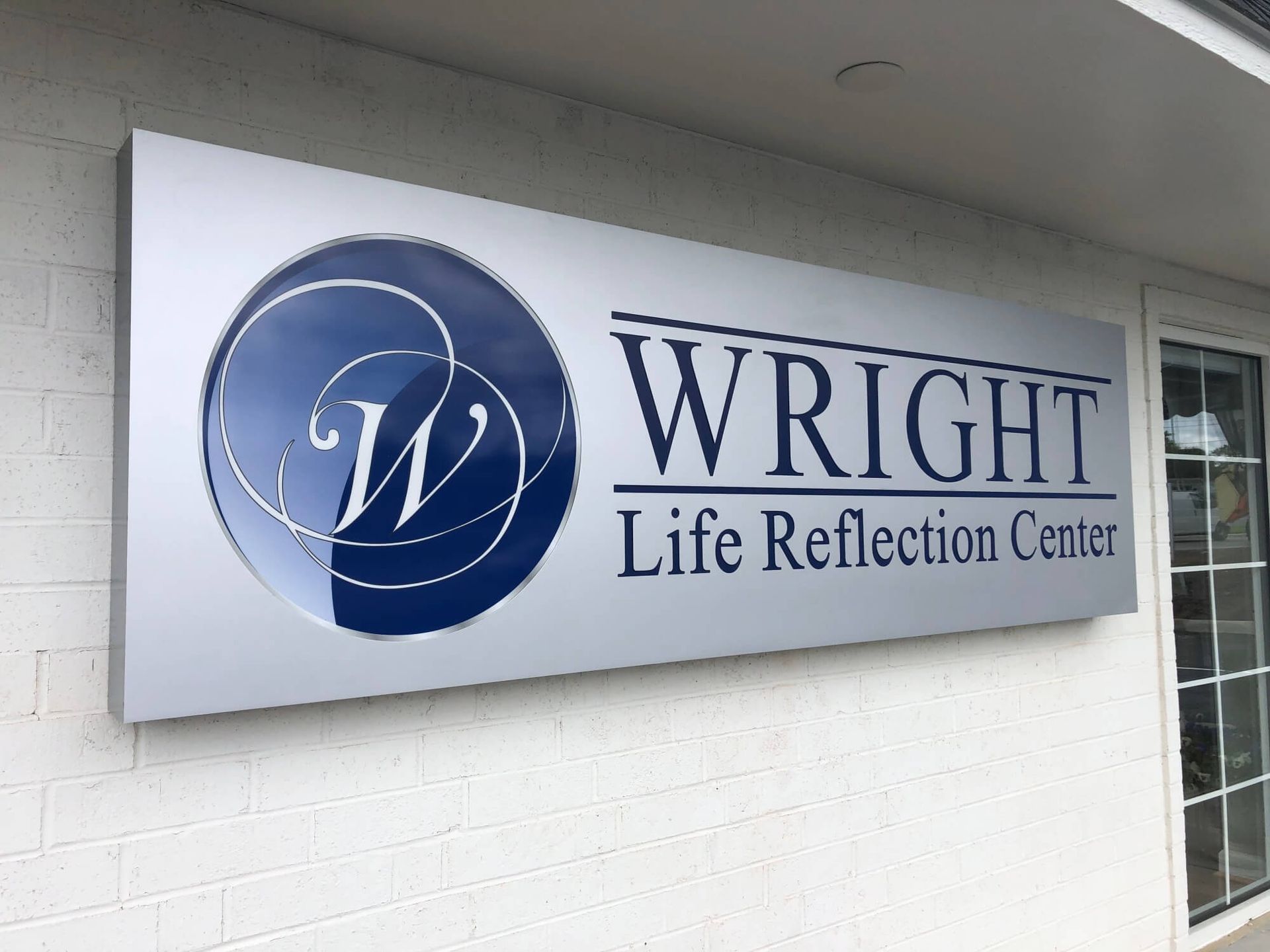 A sign on the side of a building that says wright life reflection center