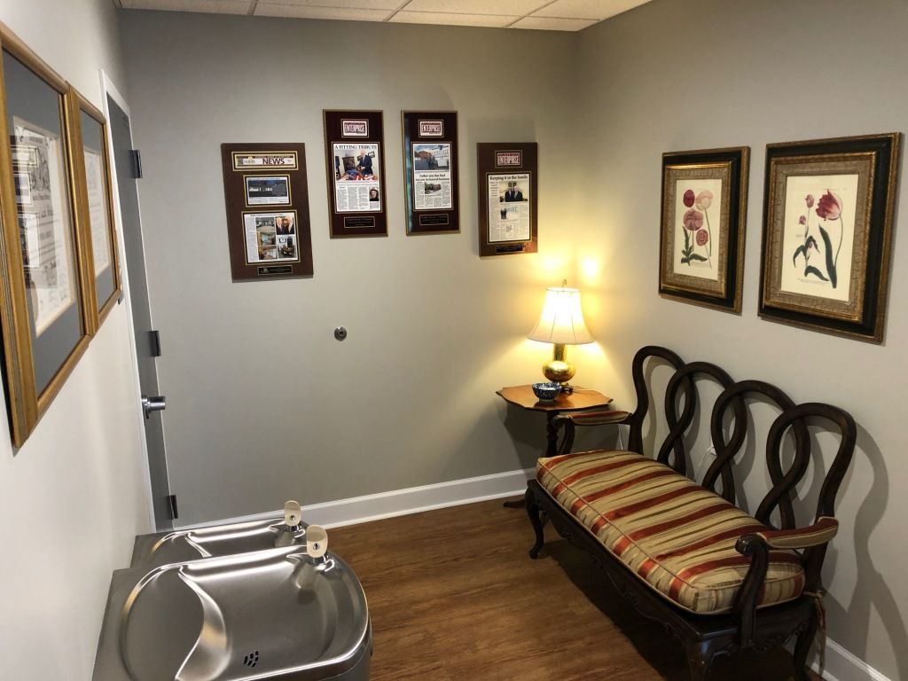 A waiting room with a bench and a sink