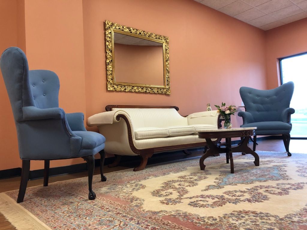 A living room with a couch and two chairs