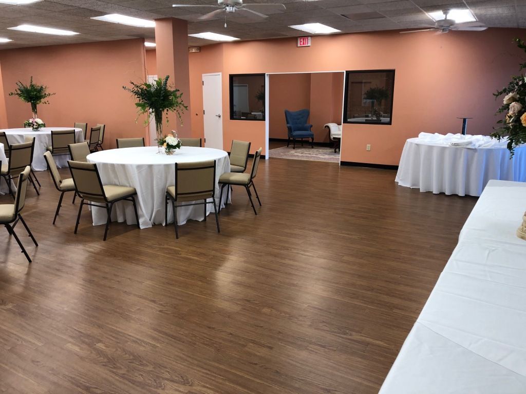 A large room with tables and chairs set up for a party.