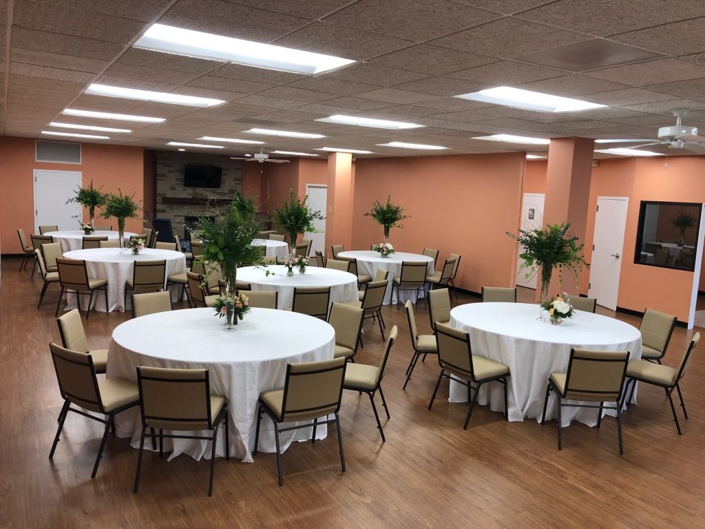 A large room with tables and chairs set up for a party