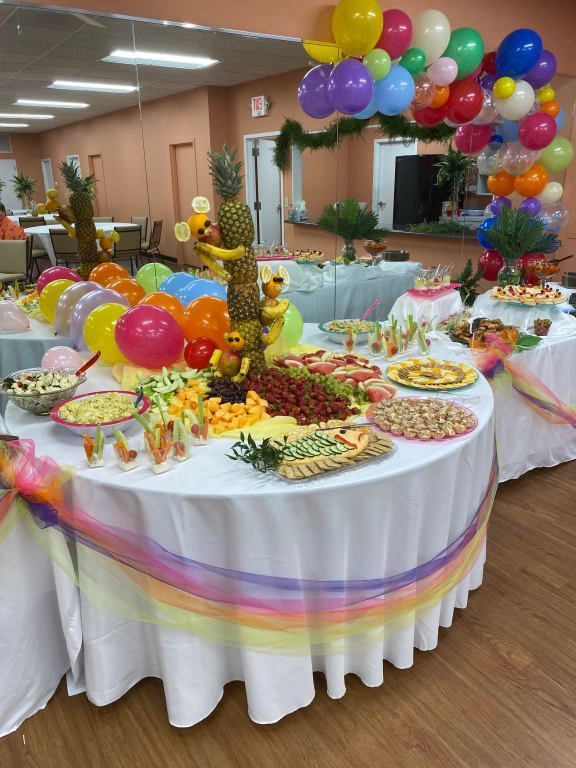 A table with a bunch of food and balloons on it