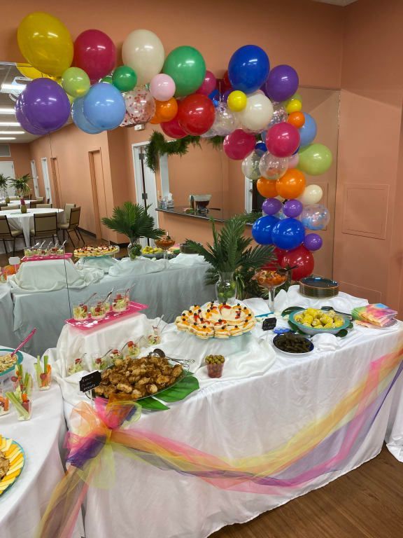 A table with food and balloons on it