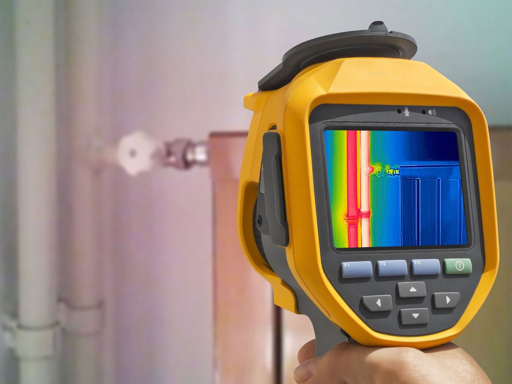 A person is holding a thermal camera in their hand.