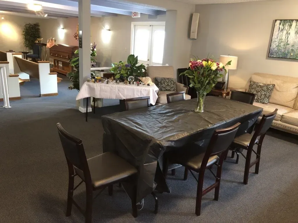 Dining room with tables set for an event, including white and black tablecloths and flower centerpieces.