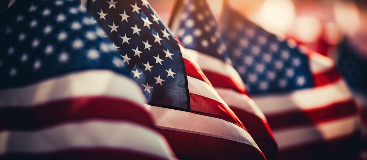 Close-up of waving American flags with red, white, and blue stripes and stars