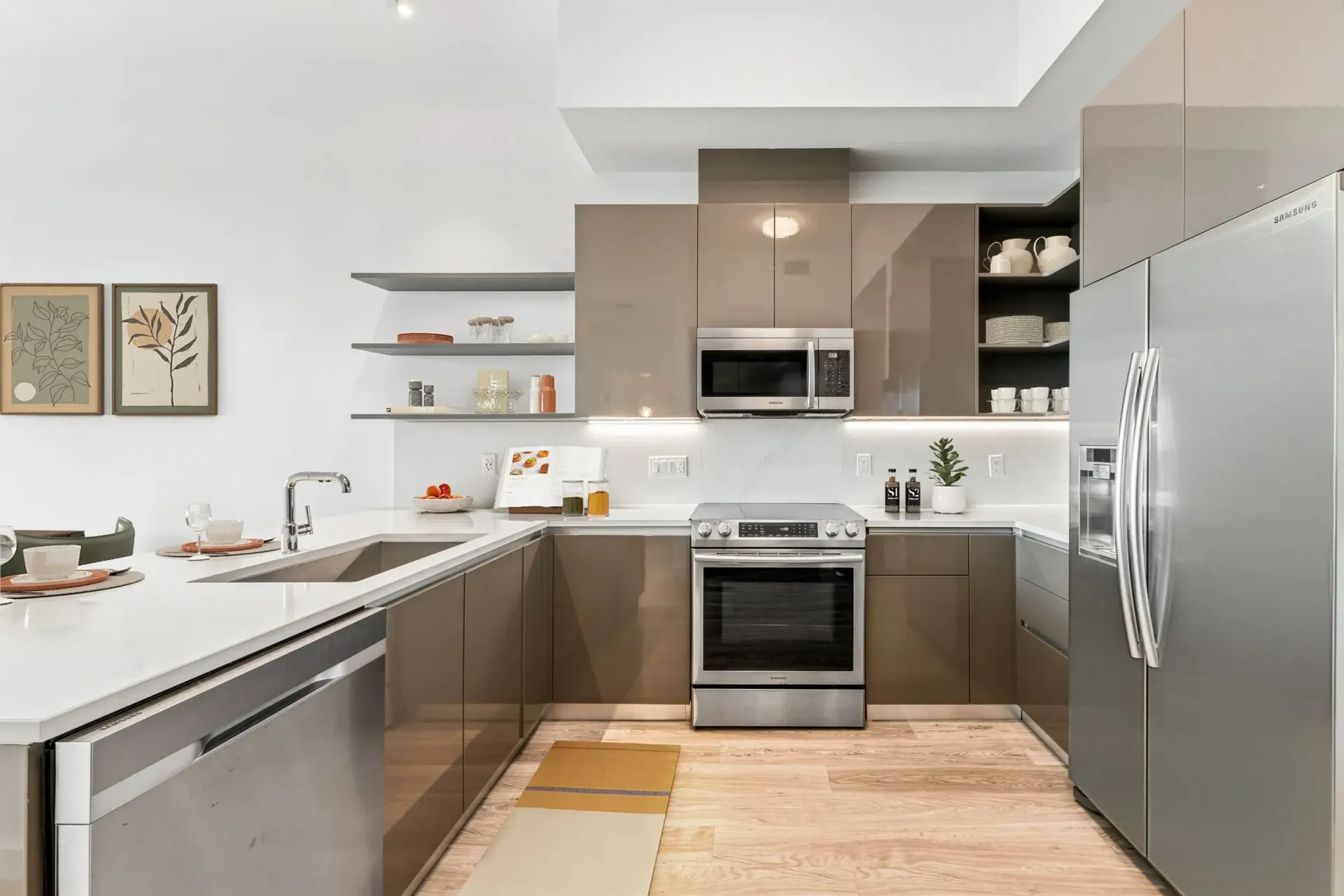 Modern kitchen with stainless steel appliances, glossy brown cabinets, and white countertops.