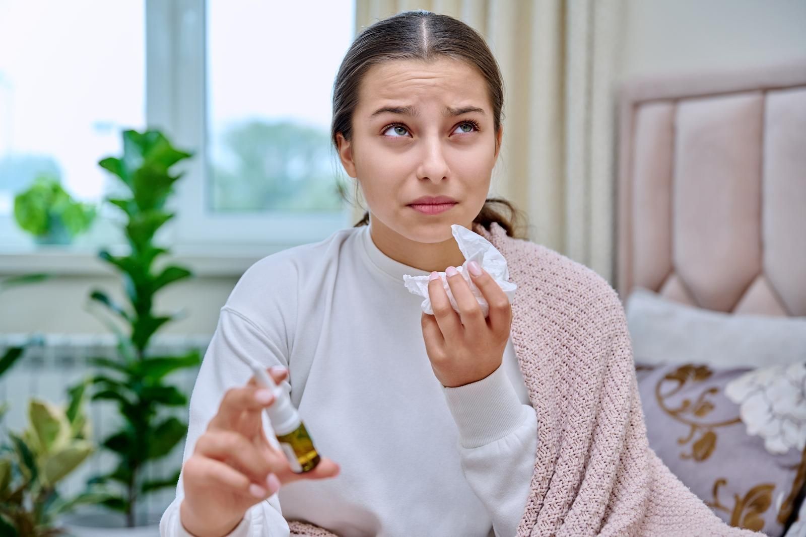 Teenage Girl With Runny Nose Treating Rhinitis Using Nose Drops Spray