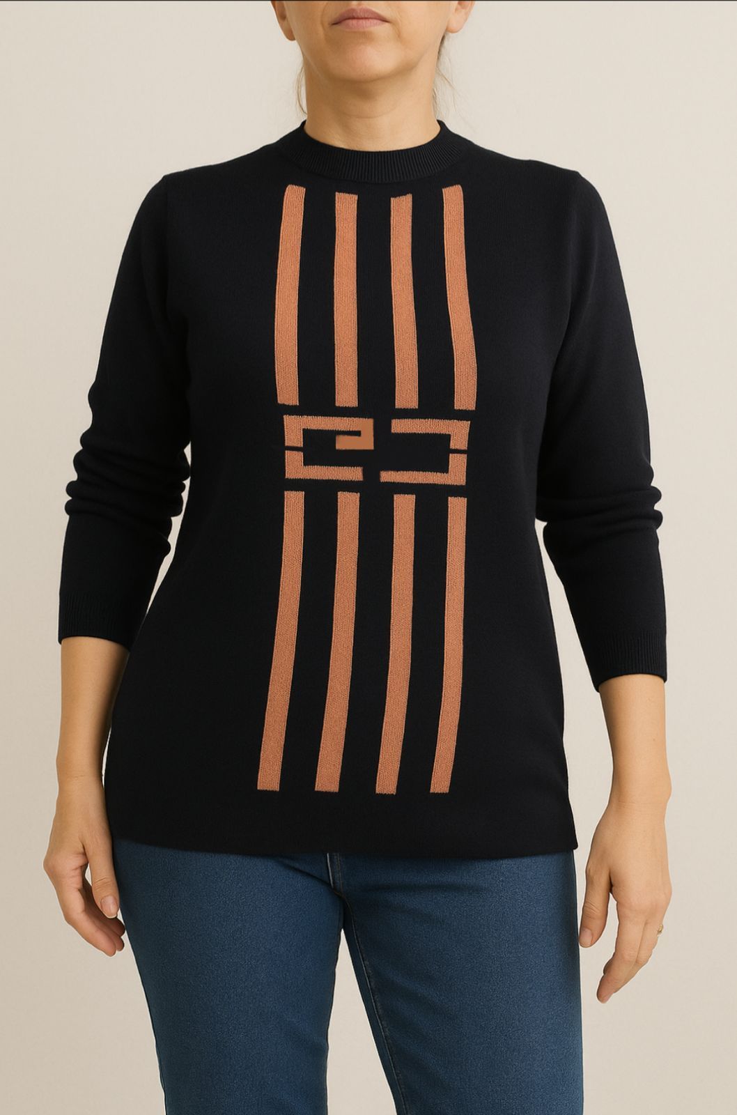 Mujer vestida con un suéter azul marino con rayas verticales cobrizas y jeans.