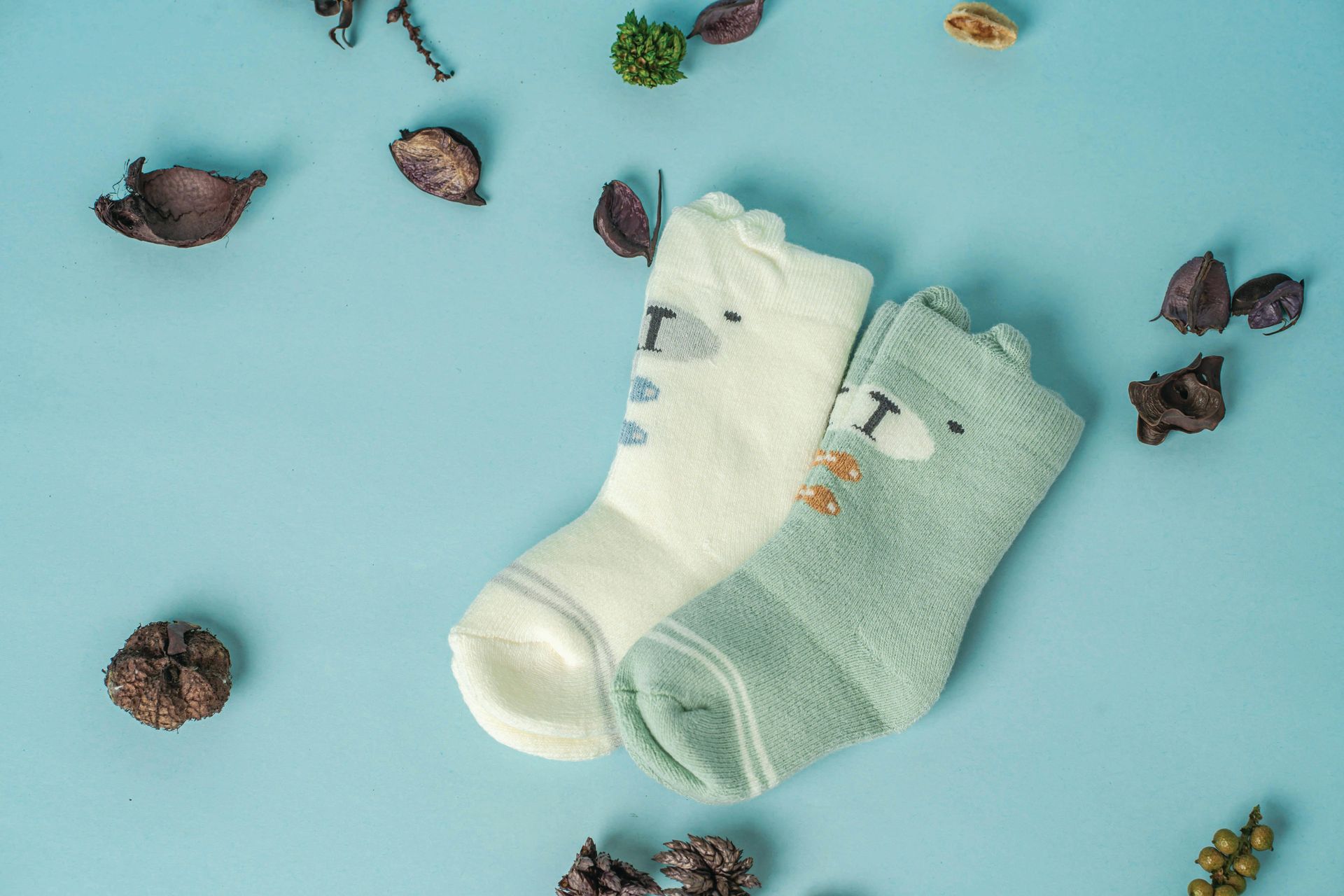 Dos pares de calcetines mullidos para bebé, uno color crema y otro verde azulado