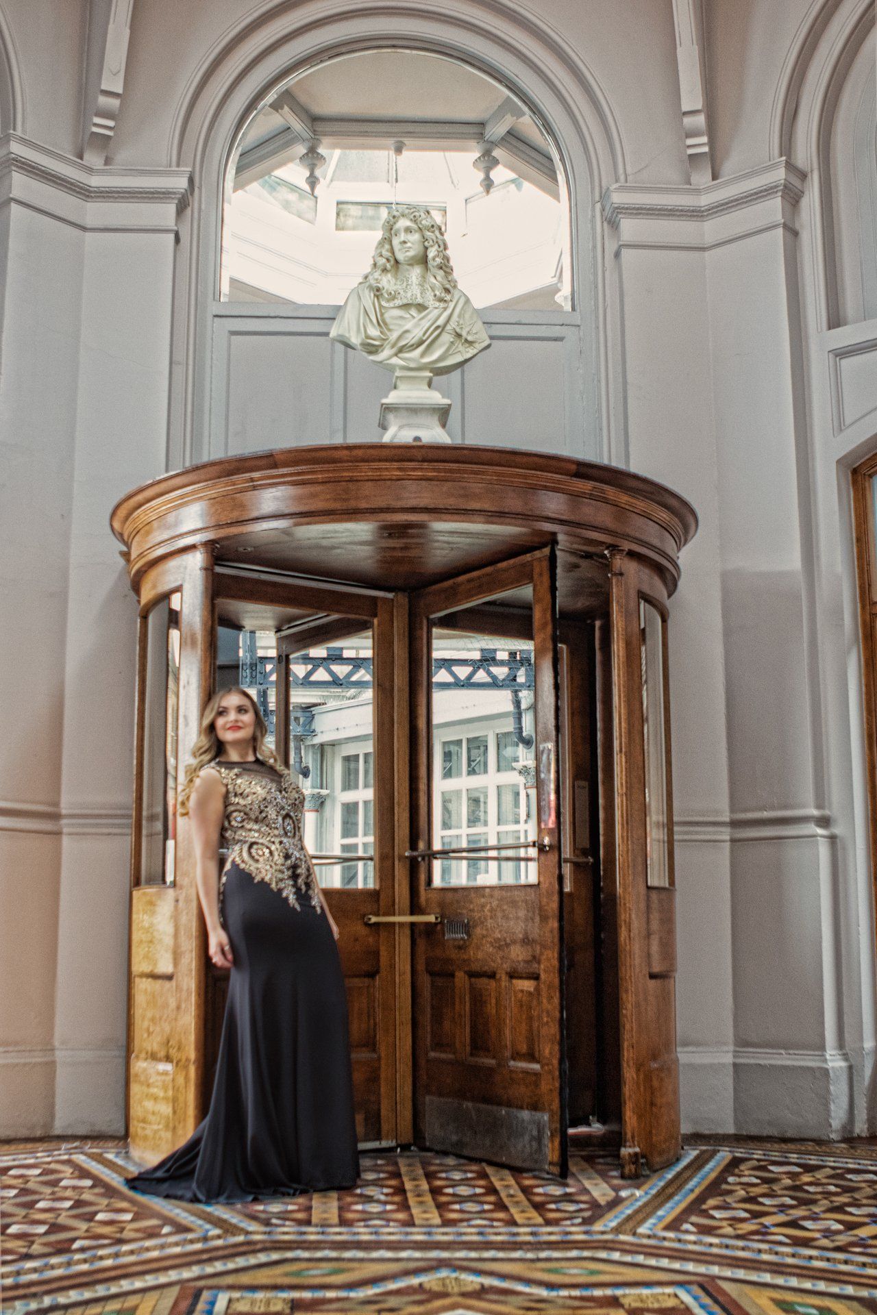 Young woman in beautiful evening gown posing in the Victorian revolving door at The Principal Hotel, York