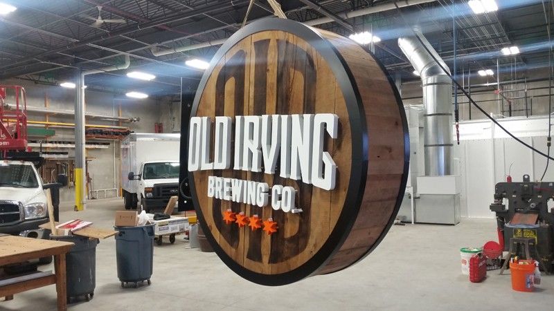 Old Irving Brewing Co. circular wood sign in a warehouse workshop
