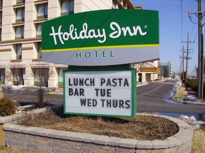Holiday Inn Hotel sign, green and white, advertising