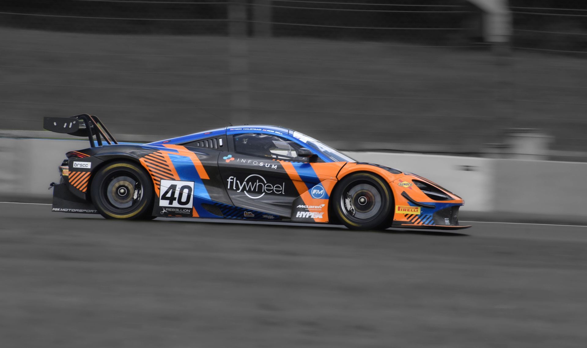 Orange-and-blue race car speeding on a track, number 40 visible on the side.