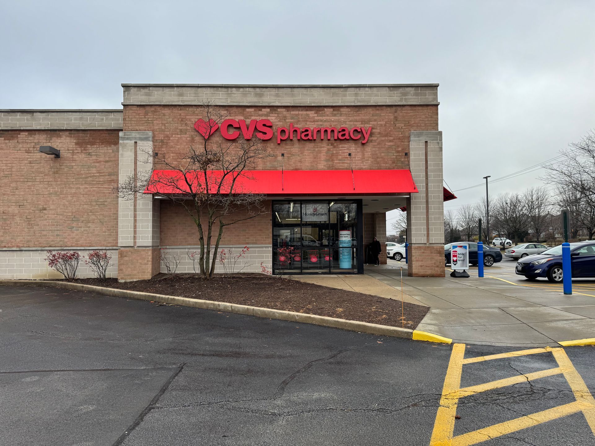 CVS Pharmacy storefront with red awning and brick facade on a cloudy day