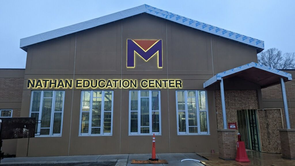 Nathan Education Center building exterior with purple-and-gold logo and front entrance windows