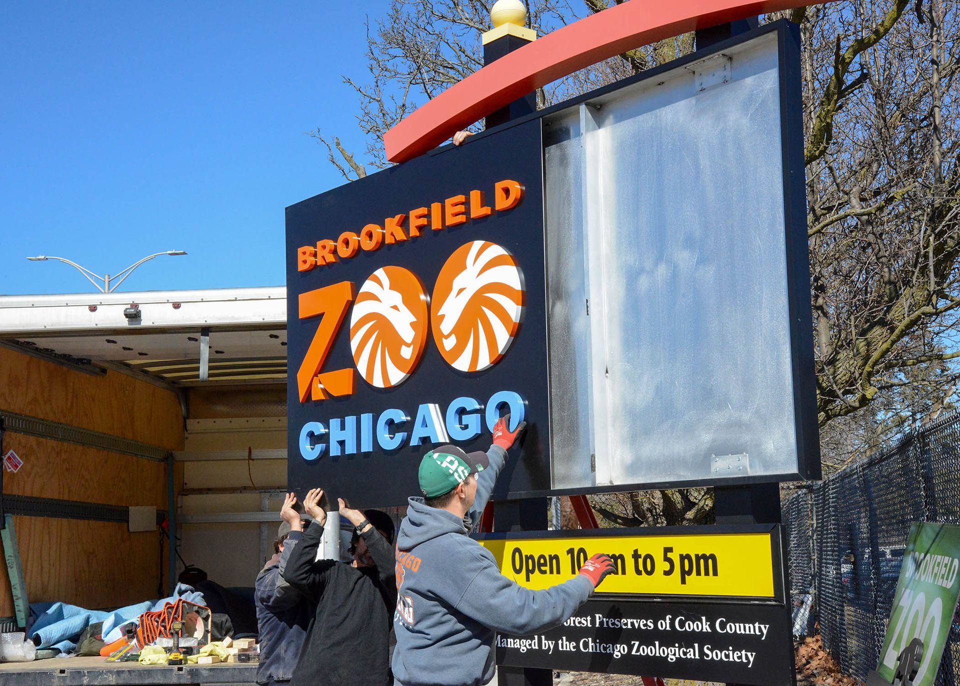 Chicago storefront mural reading “Brookfield Zoo Chicago” with two people standing nearby.