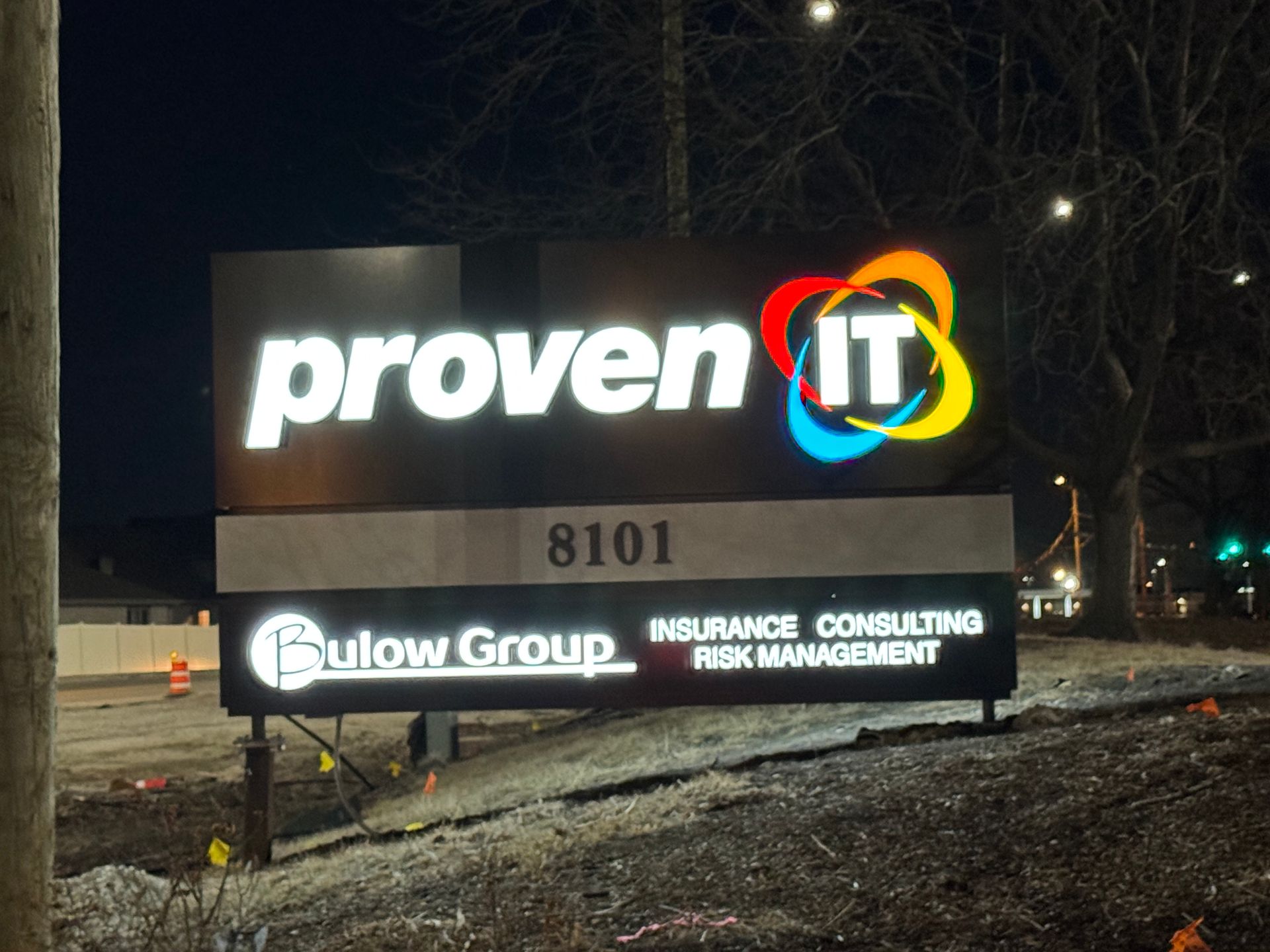 Illuminated ProvenIT and Fowl Group business sign at night with address 8101