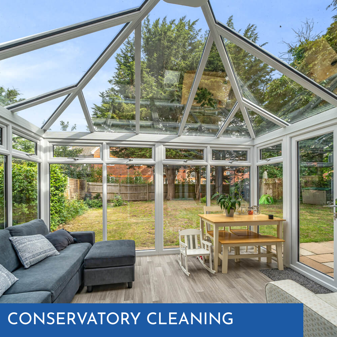 Conservatory with glass roof, white frames, gray sofa, small table, backyard view. Text overlay: Conservatory Cleaning.