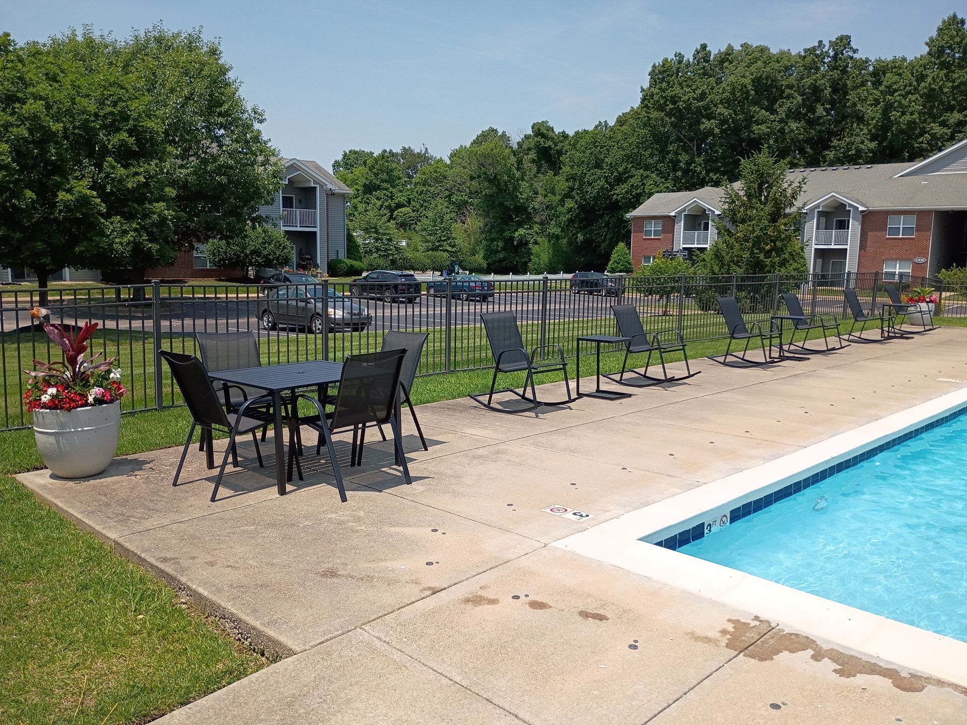 A swimming pool with a table and chairs next to it