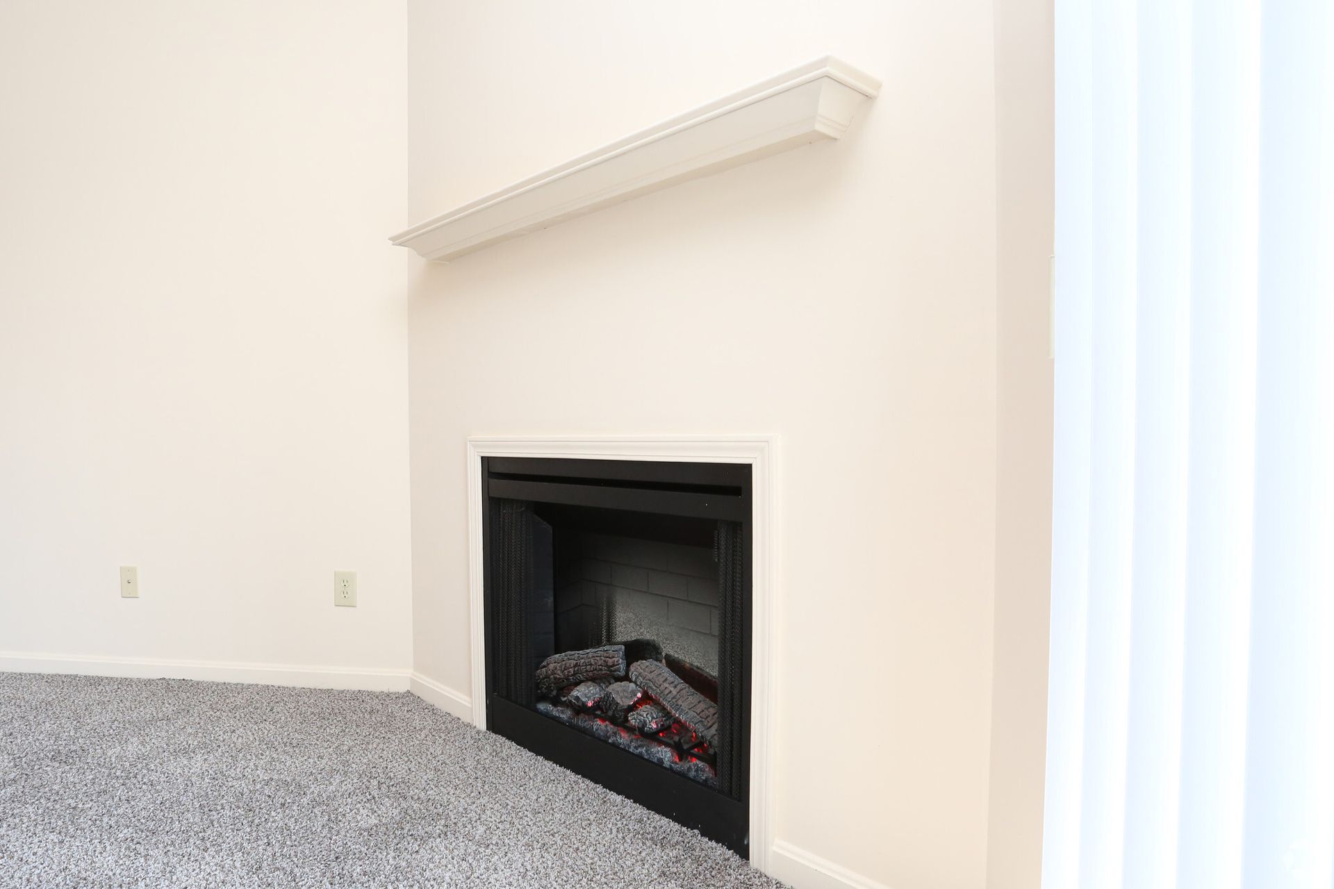 There is a fireplace in the corner of the living room.