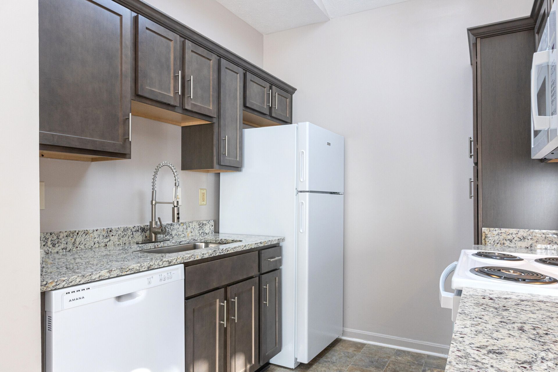 A kitchen with a refrigerator , dishwasher , stove and sink.