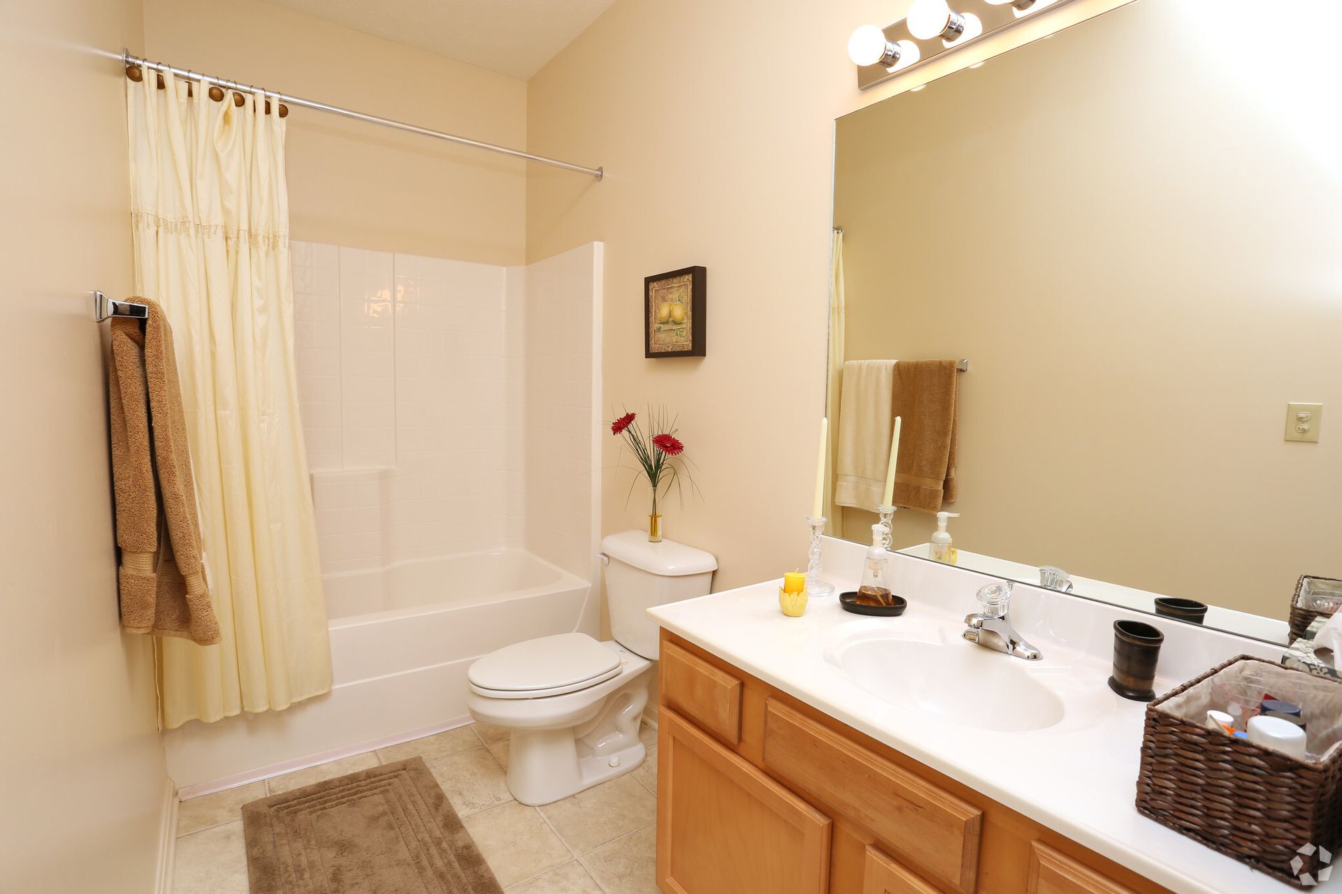 A bathroom with a sink , toilet , bathtub and mirror.
