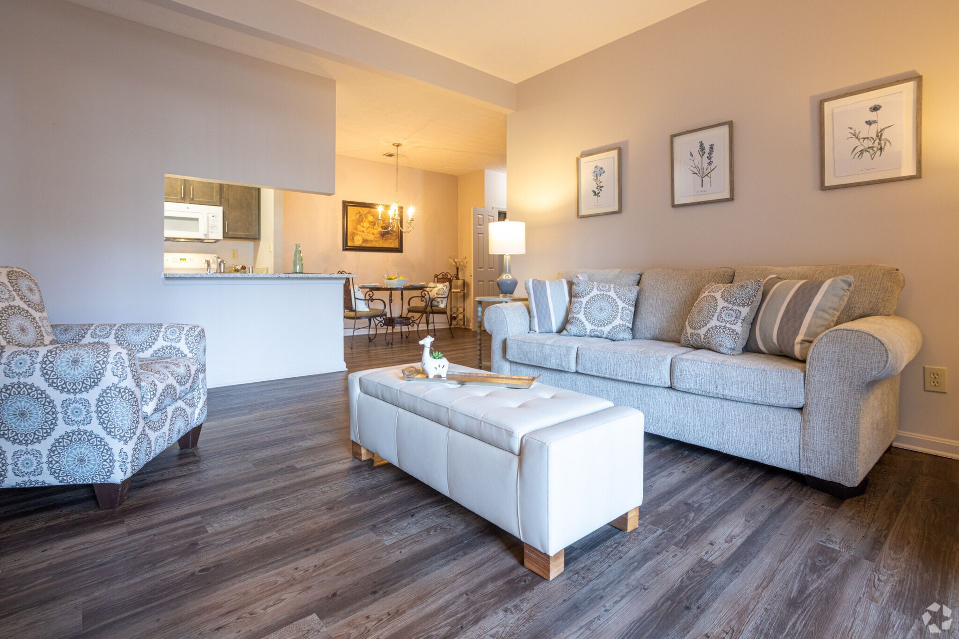 A living room with a couch , chair , coffee table and ottoman.