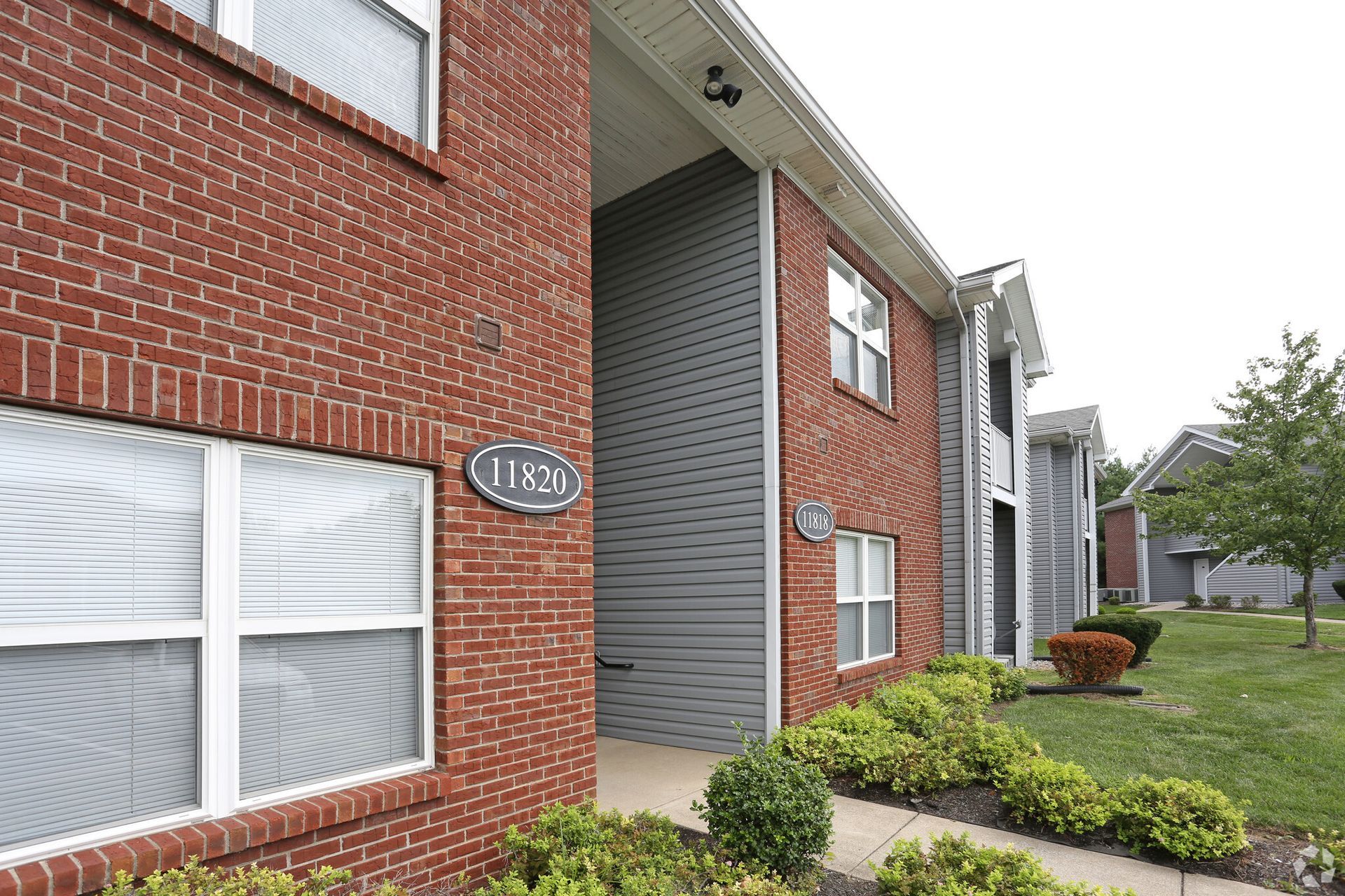 A brick apartment building with a sign on the side that says 1120