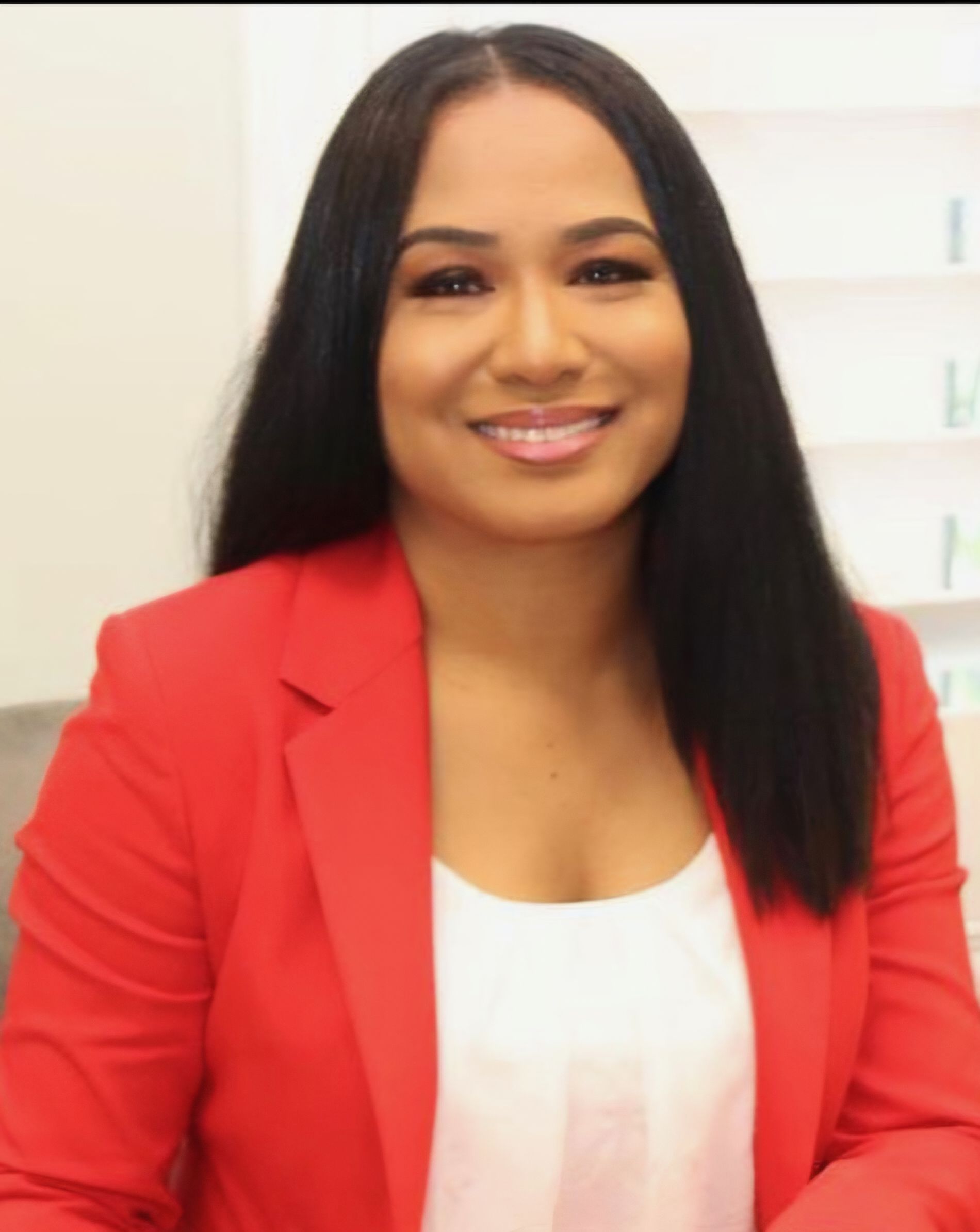 Smiling Black woman judge wearing a black robe, pearl necklace, and dark curly hair.