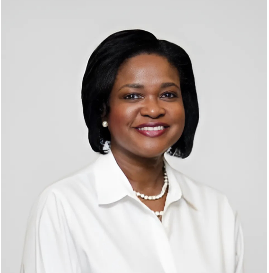 Smiling Black woman with dark hair, wearing a white collared shirt and pearl necklace.