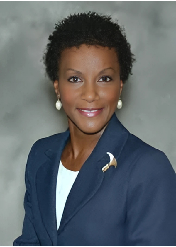 Professional portrait of a smiling Black woman in a navy blazer with pearl earrings.