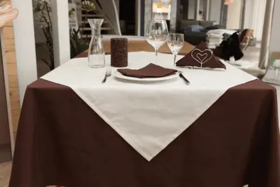 tavolo con tovaglia bianca e tovaglia marrone
