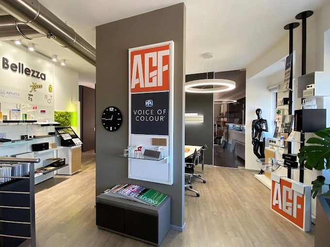 Interno moderno di un negozio di ottica con espositore per occhiali AGF e scaffali pieni di montature.