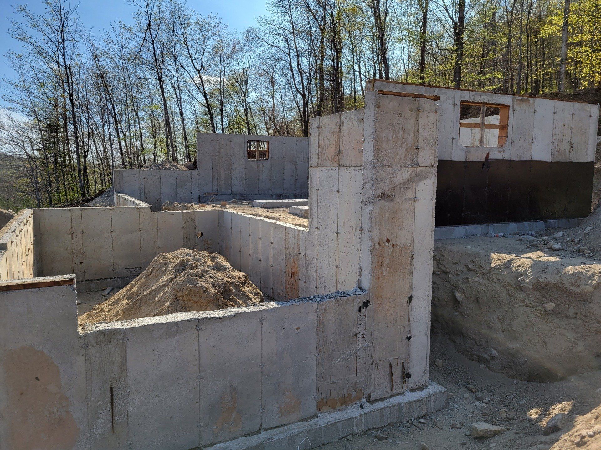 Un mur de béton est en train d'être construit au milieu d'une forêt.