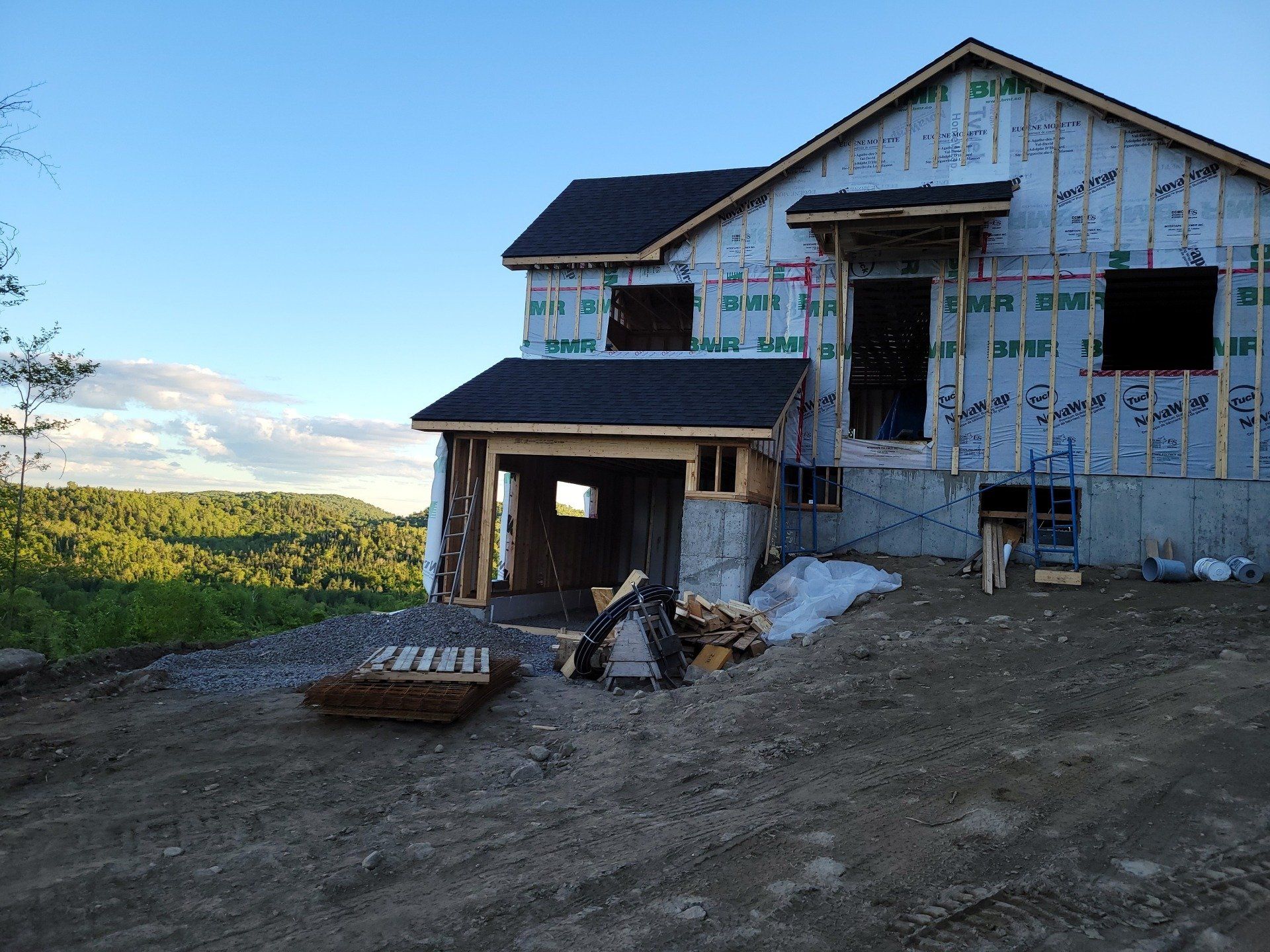 Une maison est en construction au milieu d'un champ de terre
